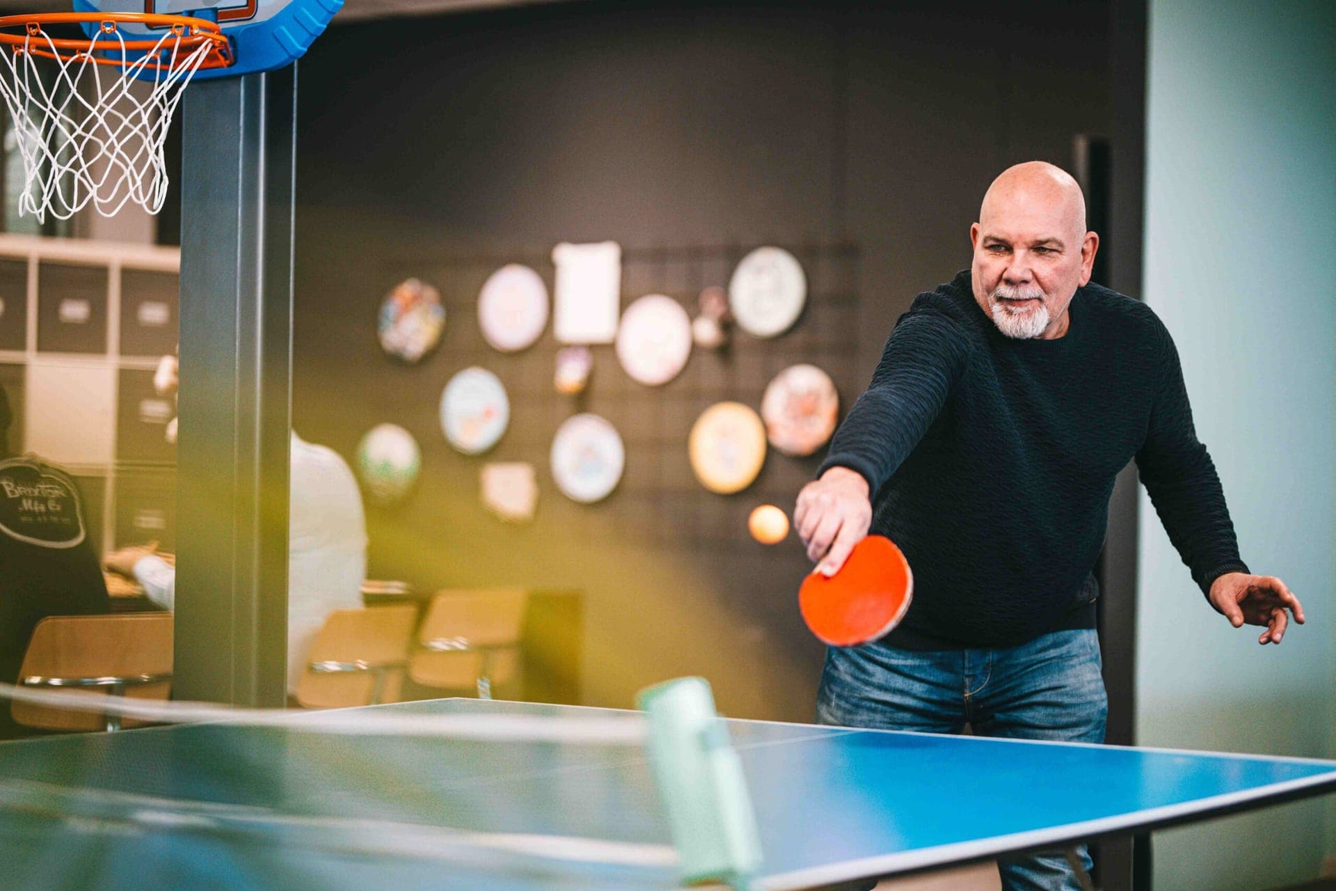 Colleague playing table tennis in the office